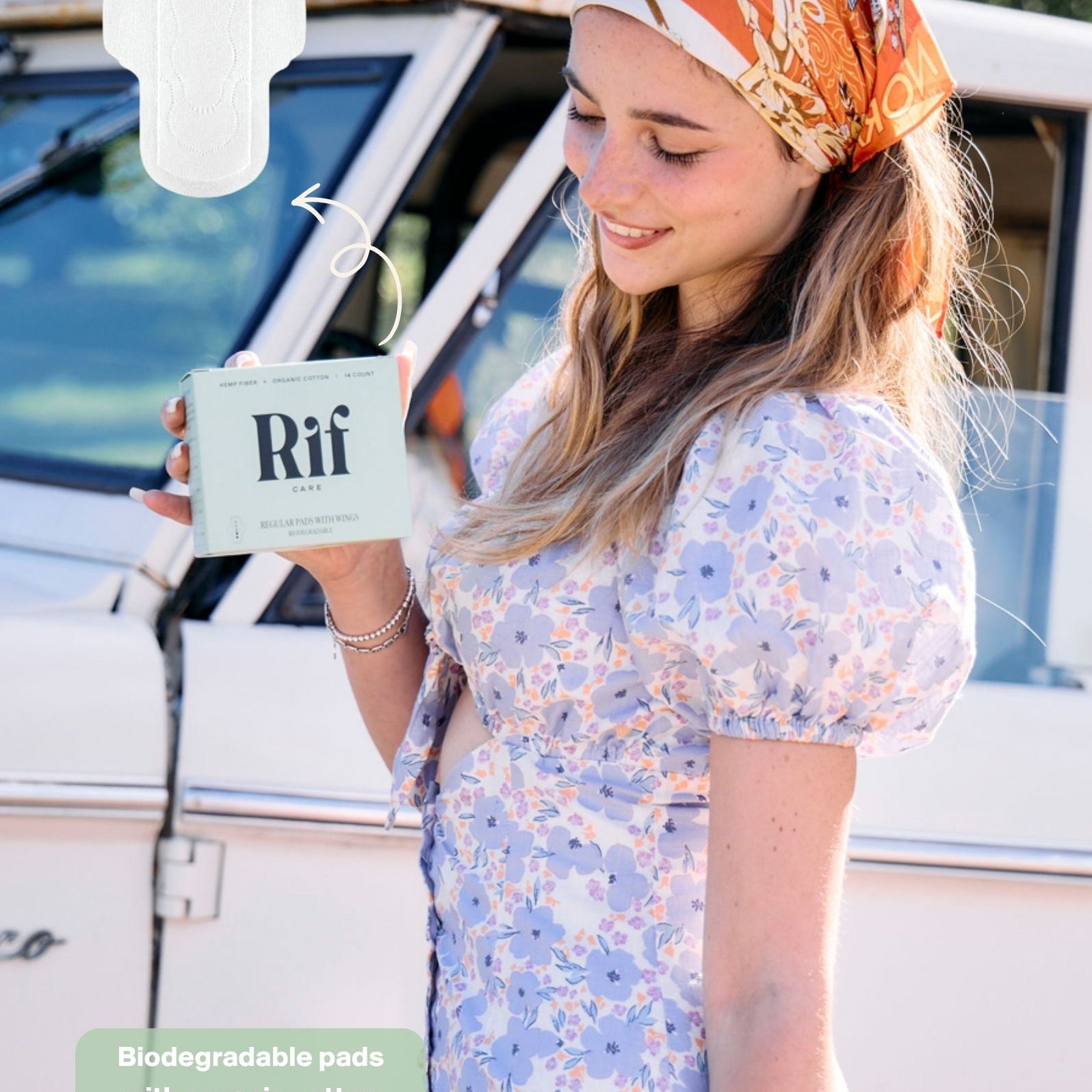 Woman holding a Rif Care regular absorbency hemp pads with a car and greenery in the background